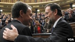 El presidente saliente y el electo, José Luis Rodríguez Zapatero y Mariano Rajoy se saludan al acabar la sesión de investidura.