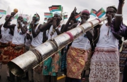 FILE - Civilians celebrate the signing of peace agreement between the Sudan's transitional government and revolutionary movements to end decades-old conflict, in Juba, South Sudan, Oct. 3, 2020.