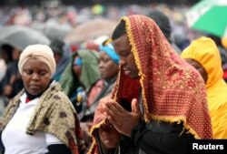 The faithful pray in the rain as Pope Francis celebrates Mass at Zimpeto Stadium in Maputo, Mozambique, Sept. 6, 2019.