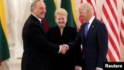 La presidenta de Lituania, Dalia Grybauskaite (centro) ría mientras el presidente de Letonia, Andris Berzins (izquierda) saluda al vicepresidente Joe Biden.