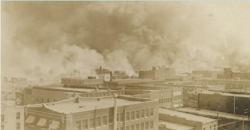 سن 1921 میں ٹلسا میں ’سیاہ فاموں کی وال اسٹریٹ‘ کو سفید فام ہجوم کے آگ لگانے کے بعد عمارتوں سے دھواں اٹھ رہا ہے۔ فائل فوٹو
