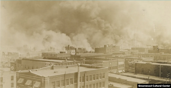 سن 1921 میں ٹلسا میں ’سیاہ فاموں کی وال اسٹریٹ‘ کو سفید فام ہجوم کے آگ لگانے کے بعد عمارتوں سے دھواں اٹھ رہا ہے۔ فائل فوٹو