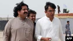 FILE PHOTO: Ali Wazir, left, and Mohsin Dawar, leaders of the Pashtun Tahaffuz Movement (PTM) walk at the venue of a rally against, what they say, are human rights violations by security forces, in Karachi, Pakistan, May 13, 2018. 