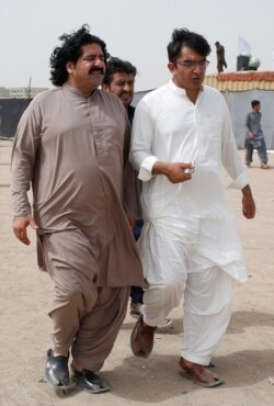 FILE - Ali Wazir, left, and Mohsin Dawar, leaders of the Pashtun Tahaffuz Movement (PTM) walk at a rally in Karachi, Pakistan, May 13, 2018.