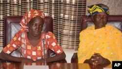 FILE - Amina Ali, left, the first rescued Chibok schoolgirl, and her mother, Binta Ali Nkeki attend a meeting with Nigeria's President Muhammadu Buhari at the Presidential palace in Abuja, Nigeria. 