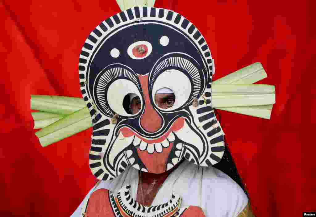 A dancer in traditional attire waits to take part in a performance during the festivities marking the start of the annual harvest festival of "Onam," in Kochi, India.