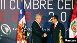 Chile's President Sebastian Pinera (L) and his Peruvian counterpart Ollanta Humala shake hands during a joint news conference at the Community of Latin American and Caribbean States (CELAC) summit in Havana, Jan. 29, 2014.