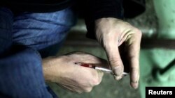 Pengguna narkoba menyuntikkan heroin ke tangannya. 