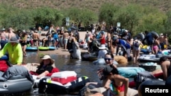 Orang-orang bersiap untuk bermain tubing di Salt River di Arizona, AS, 27 Juni 2020. Seorang laki-laki asal Minnesota berusia 54 tahun pada Kamis (11/4) divonis bersalah membunuh seorang siswa SMA dan menikam empat orang lain yang sedang tubing. (Foto: REUTERS/Cheney Orr)