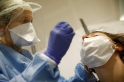 A health-care worker collects a swab sample to be tested with the Coronavirus at the European Parliament in Strasbourg, eastern France, May 12, 2020.