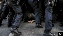 Police officers remove anti-far-right protesters blocking the route of a far-right demonstration, a day before the German election, in Berlin, Germany, on Feb. 22, 2025.