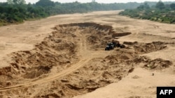 Para buruh bekerja di tambang pasir di sungai Meshwo dekat Mehamdabad, sekitar 25 km dari Ahmedabad, India, 20 November 2009. (Foto: AFP)