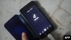 FILE - This illustration photo taken on June 29, 2020 shows a person using the video-sharing app TikTok on a smartphone in New Delhi.