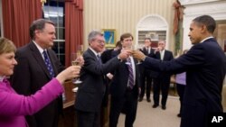 President Barack Obama shares a toast in the Oval Office with the members of his National Security Staff who worked on the New START nuclear arms control agreement, 22 Dec 2010.