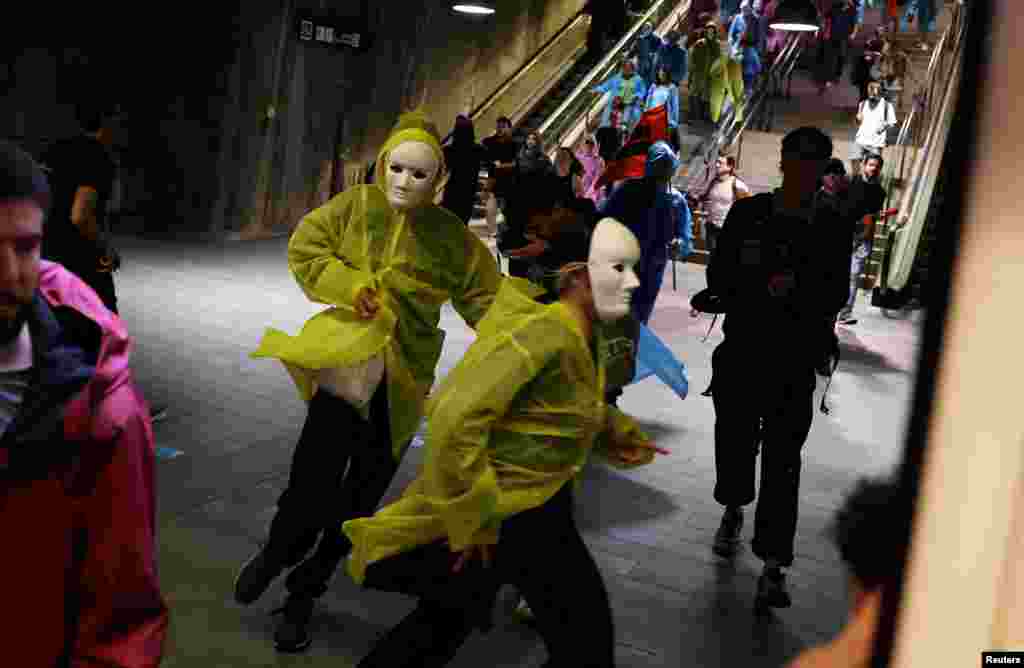 Demonstrators run inside a subway station after clashing with riot police during a protest to denounce the housing crisis and evictions, in Barcelona, Spain.