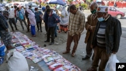 Ethiopians check newspapers and magazines reporting on the current military confrontation in Ethiopia's Tigray region, at a news stand on a street in the capital Addis Ababa, Nov. 7, 2020.