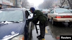 Seorang tentara Taliban memeriksa kendaraan di sebuah pos pemeriksaan di Kabul, Afghanistan, 3 Januari 2022. 