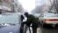 FILE - A Taliban member searches a car as he stands guard at a checkpoint during a snowfall in Kabul, Afghanistan, Jan. 3, 2022. 