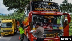 Ilustrasi - Petugas memeriksa bus pada hari pertama larangan mudik lewat laut, darat, udara, dan kereta api menjelang lebaran, dalam upaya mencegah penularan COVID-19, 6 Mei 2021, (Antara Foto / Adeng Bustomi / via Reuters.)