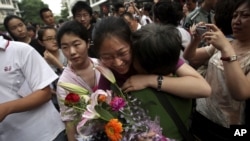 A Chinese student is greeted by a relative after attending the end of the annual college entrance examinations, in Beijing, China, Tuesday, June 8, 2010. Each year, about 10 million high school seniors across China take the "gaokao" -- the exam that is th