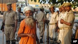 Indian security personnel stand guard as an elderly man walks past on September 29, 2010 in Ayodhya, on the eve of a court ruling that divided a long-contested holy site in the city between Hindus and Muslims (AFP).