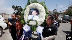 Cambodian community activists carry a wreath during the funeral procession of government critic Kem Ley in Phnom Penh, July 11, 2016. 