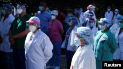 Médicos y personal de salud del Instituto Salvadoreño del Seguro Social (ISSS) protestan frente a un hospital para pedir equipo de protección personal (EPP) y mejores condiciones de trabajo, en Soyapango, El Salvador, el 14 de julio de 2020.