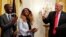 President Donald Trump, right, gives the thumbs up to Cam'eron Hill, left, and his mother LaSonya Hill, of Jacksonville, Fla., during an event about taxes, June 29, 2018, in the East Room of the White House in Washington.