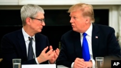 President Donald Trump talks to Apple Inc. CEO Tim Cook during the American Workforce Policy Advisory Board's first meeting in the State Dining Room of the White House in Washington, Wednesday, March 6, 2019.