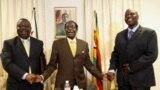 President Robert Mugabe, centre, shares a light moment with Morgan Tsvangirai, left, Zimbabwe's Prime Minister and his Deputy, Arthur Mutambara after giving their end of year message to the nation, at Zimbabwe House in Harare, Wednesday, Dec. 23, 2009. Th