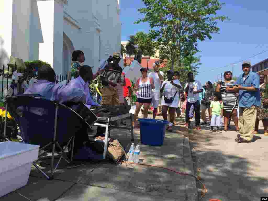 A group sings outside of Emanuel AME church in Charleston, South Carolina, June 21, 2015. (Amanda Scott/VOA)