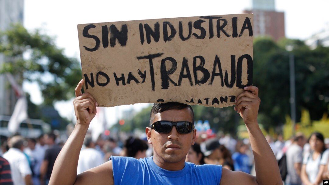 A demonstrator holds a sign that reads in Spanish "Without industry there is no work" during a labor march in Buenos Aires, March 7, 2017. 