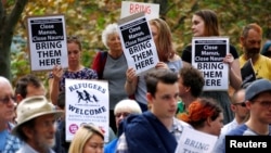 FILE - Protesters from the Refugee Action Coalition hold placards during a demonstration outside the offices of the Australian Government Department of Immigration and Border Protection in Sydney, Australia, April 29, 2016. 