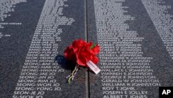 FILE - A bouquet rests on a section of the Korean War Veterans Memorial's Wall of Remembrance, July 27, 2022, in Washington. 