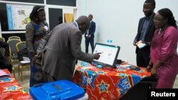 Un homme s'exerce à utiliser une machine à voter électronique lors d'une manifestation devant le siège de la commission électorale du Congo (CENI) à Gombe, dans la municipalité de Kinshasa, en RDCongo, le 1er mars 2018. EUTERS/Robert Carrubba - RC1DFD65E690