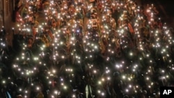 Pro-democracy protesters shine their mobile phone lights during an anti-government protest at Victory Monument during a protest in Bangkok, Thailand, Oct. 18, 2020.