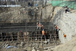 Afghan laborers work on a bridge project funded by the government, in Kabul, Afghanistan. Rebuilding war-torn Afghanistan has cost thousands of lives, according to a new U.S. government report.