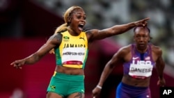 Jamaica's Elaine Thompson-Herah celebrates after winning the women's 100m at the Tokyo Olympics, July 31, 2021.