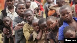 Refugee children, displaced by continued fighting in north Kivu province in the Democratic Republic of Congo (DRC), wait for food in the Nyakabande refugee transit camp in Kisoro town, 521 km (324 miles) southwest of Uganda's capital Kampala, July 13, 201