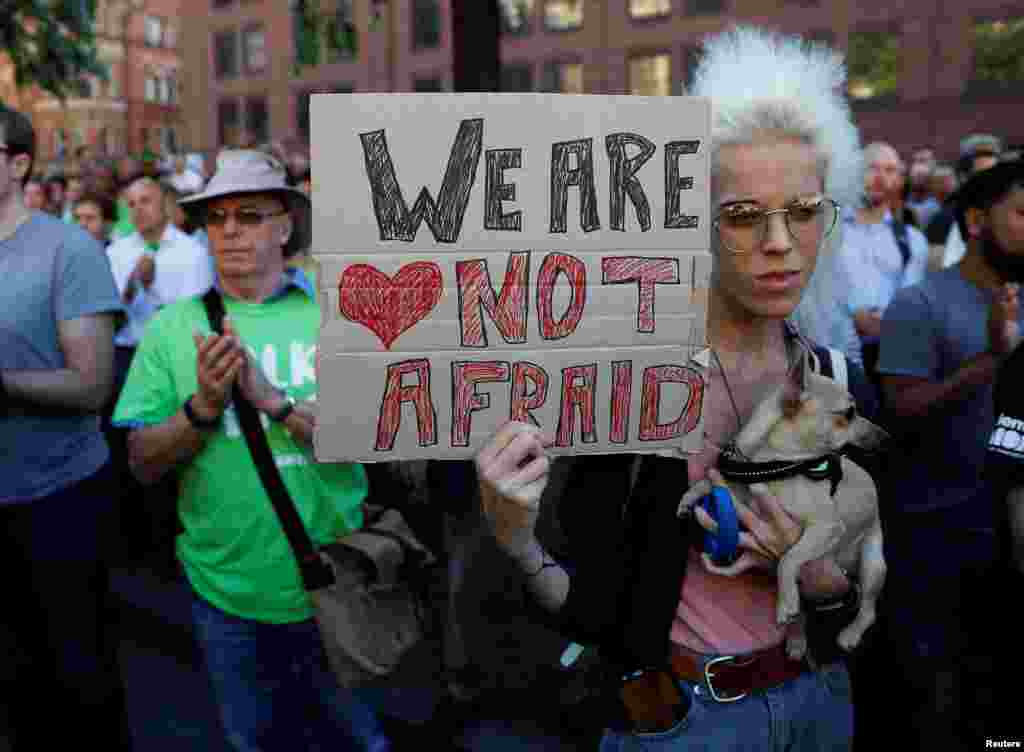 A woman holds a placard as they take part in a vigil for the victims of an attack on concert goers at Manchester Arena, in central Manchester, Britain, May 23, 2017.