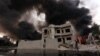 An Iraqi man walks near smoke billowing from oil wells, set ablaze by Islamic State militants before fleeing the oil-producing region of Qayyarah, Aug. 30, 2016.