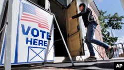 FILE - A resident arrives to cast her vote at a polling station at the Kennebunk Town Hall in Kennebunk, Maine, June 12, 2018.