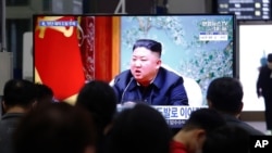 People watch a TV showing a file image of North Korean leader Kim Jong Un during a news program, March 25, 2021, at the Suseo Railway Station in Seoul, South Korea.
