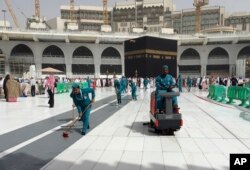Workers clean the Grand Mosque, during the minor pilgrimage, known as Umrah, in the Muslim holy city of Mecca, Saudi Arabia, Monday, March 2, 2020.
