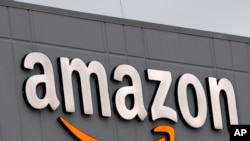 A sign is lit on the facade of an Amazon fulfillment center, Thursday, March 19, 2020, on Staten Island in New York.