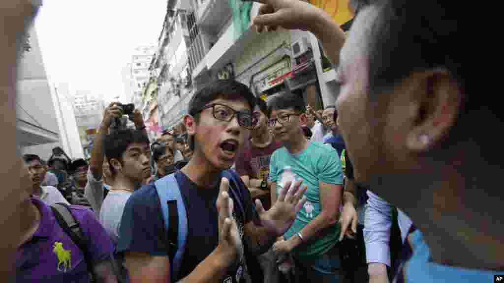 A pro-democracy student protester tries to negotiate with angry locals trying to remove the barricades blocking streets in Causeway Bay, Hong Kong, Oct. 3, 2014.