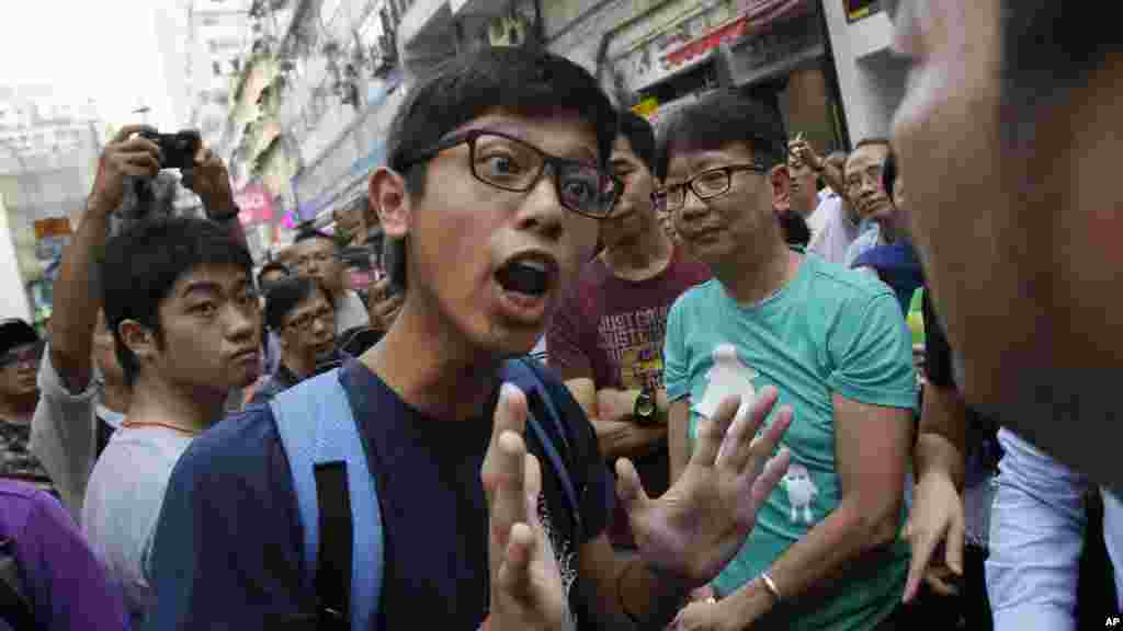 Un étudiant manifestant négocie avec les habitants du quartier en colère qui essayent de démonter les barricades bloquant des passages sur les rues de Causeway Bay à Hong Kong, le 3 octobre 2014. 