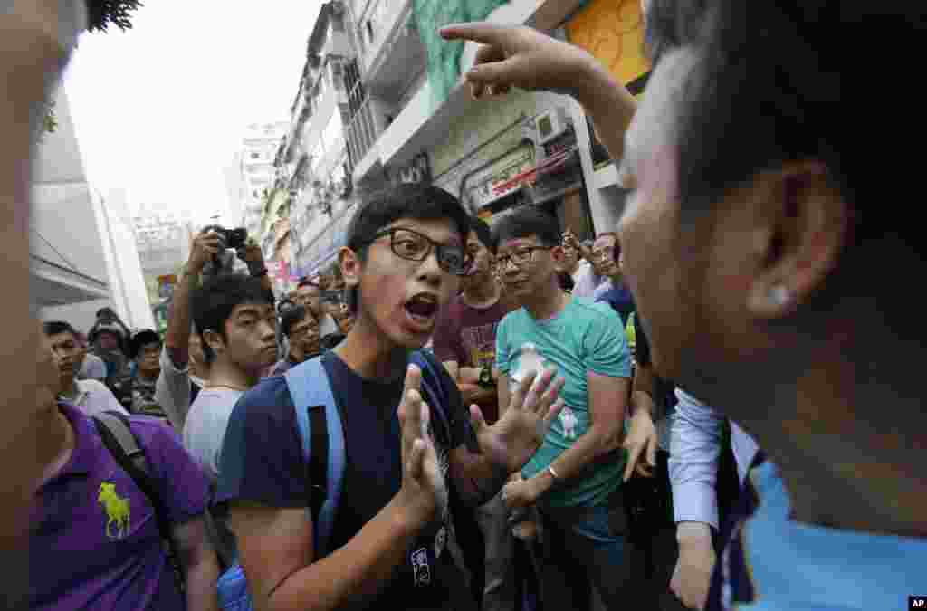 A pro-democracy student protester tries to negotiate with angry locals trying to remove the barricades blocking streets in Causeway Bay, Hong Kong, Oct. 3, 2014.