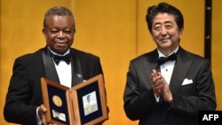 Dr Jean-Jacques Muyembe-Tamfum ya Congo démocratique azwi mbando ya edition ya misato ya Hideyo Noguch Africa na maboko ya Premier ministre ya Japon Shinzo Abe, na Tokyo, Japon, 30 août 2019.