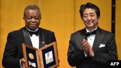 Dr Jean-Jacques Muyembe-Tamfum ya Congo démocratique azwi mbando ya edition ya misato ya Hideyo Noguch Africa na maboko ya Premier ministre ya Japon Shinzo Abe, na Tokyo, Japon, 30 août 2019.